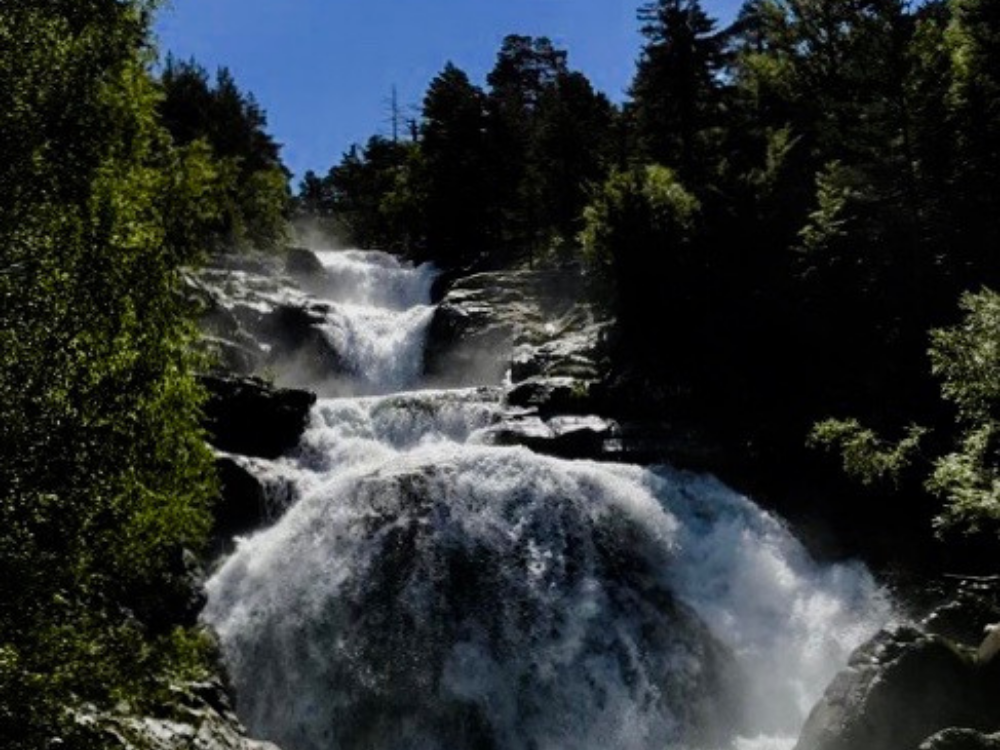 Cascada de Sant Esperit, al centre tota la imatge de la cascada d'aigua. Als laterals petita visió d'avets acompanyant l'aigua