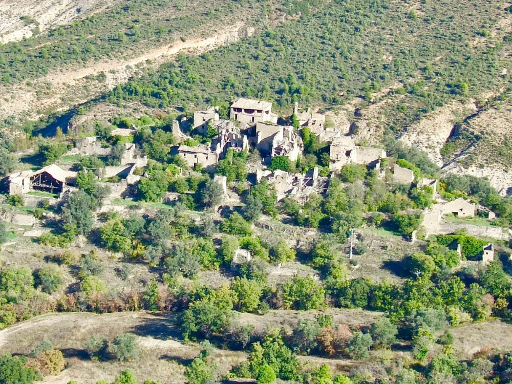 Vista aérea del pueblo abandonado de Montesquiu, rodeado de bosque y montaña