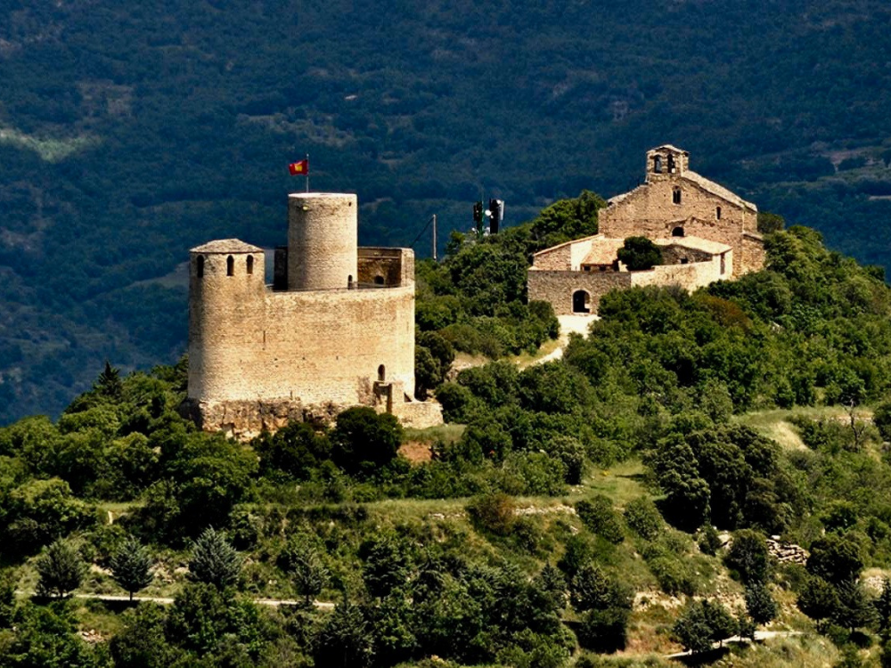 Castell de Mur, general view of the location of the castle on a mound surrounded by woods.