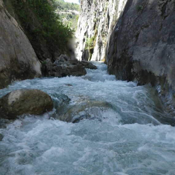 Vista del riu baixant amb força entre parets de roca grisenca