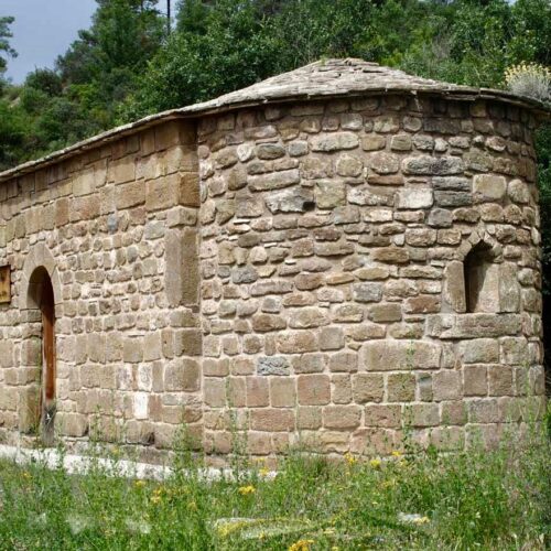 Exterior view of the apse of a small Romanesque hermitage.