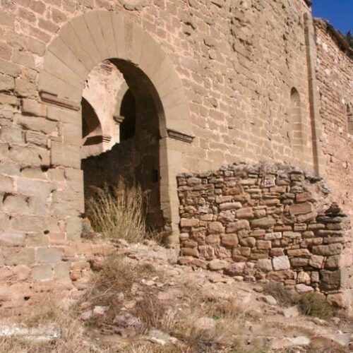 Detall de la porta principal del castell, Es veu perfectament la imposta i el gran arc amb les seves dovelles. L'entrada en ruïnes de la paret encara conservada