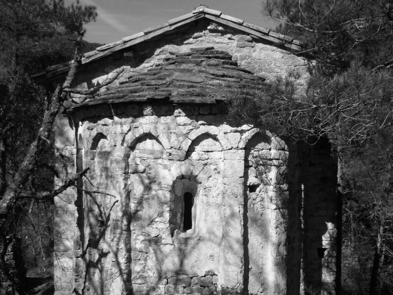 Imagen en blanco y negro de Sant Martí de Terrasola. Foto en blanco y negro apreciándose las nítidamente sombras de los árboles en el exterior del ábside de la ermita