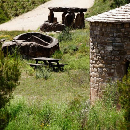 Situació de l'ermita al mig del prat . Vista al fons d'un dolmen