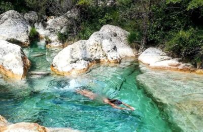 Chica nadando bajo las aguas cristalinas en una poza del río Rialb