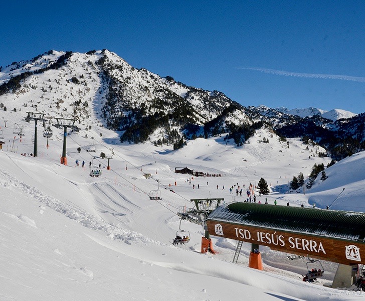 Vista de la estación de esquí Baqueira-Beret. Montaña al fondo con sus pistas de esquí arrastres, y telesillas. Cielo azul intenso que contrasta con la blanca nieve
