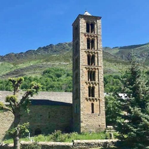 View of the Church of Sant Clement, considered one of the best Romanesque churches in the Vall de Boí, declared a World Heritage Site and built in the twelfth century. In the background the mountains with their spring green