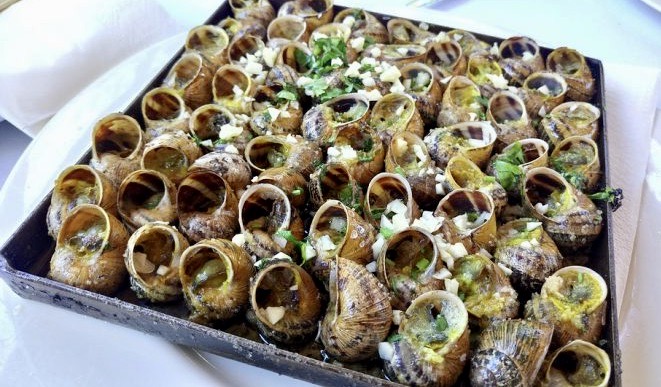 Dish of snails LLAUNA style are dried with lots of salt and black pepper with garlic and parsley.